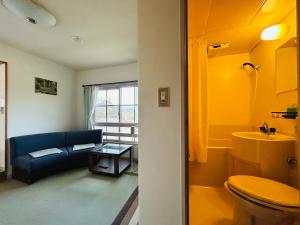 a bathroom with a couch and a toilet in a room at Hakuba Snow Fox in Hakuba +46 photos