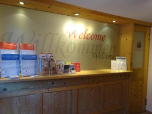 un signe de bienvenue sur le mur d'un magasin dans l'établissement Haus Zangerl, à Sankt Anton am Arlberg