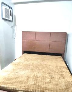 a bed with a brown headboard in a room at Zefe's Hideout in Lapu Lapu City