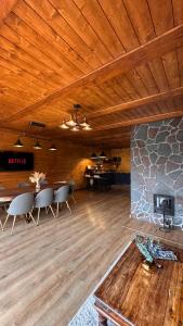 a living room with a table and chairs and a fireplace at Twin Cabins / Cabanele Gemene in Suceava