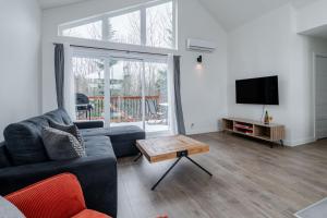 a living room with a couch and a tv at Pool Spa sauna & Pool Table - Beaulieu 110 in Pont-Rouge