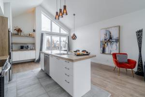 a kitchen with a sink and a red chair at Pool Spa sauna & Pool Table - Beaulieu 110 in Pont-Rouge