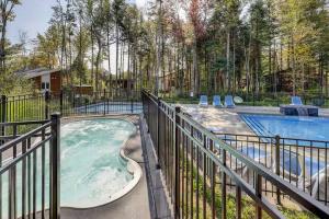 a hot tub on a fence next to a swimming pool at Pool Spa sauna & Pool Table - Beaulieu 110 in Pont-Rouge