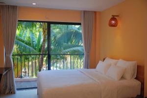 a bedroom with a bed and a large window at Cham Riverside in Thôn Xuân Lạc