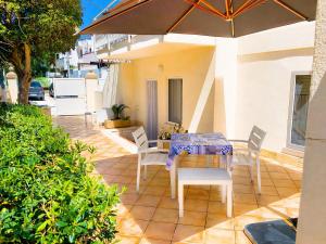 a table and chairs with an umbrella on a patio at BeachSide Rooms & Suites in San Vito lo Capo