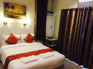 a hotel room with a bed with two towels on it at Apinsaya House in Ban Pa Sang (1)