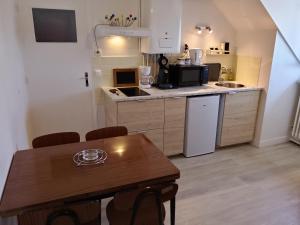 a small kitchen with a wooden table and a dining room at L'escale Vernonnaise in Vernon +10 photos