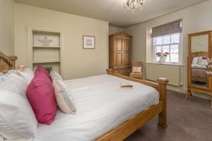 a bedroom with a large bed with pink pillows at 2 Bed in Warkworth oc-coq95 in Warkworth