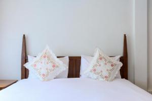 two beds with white sheets and pillows at Samer Boutique Stay in Bangkok