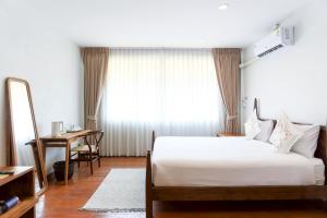 a bedroom with a bed and a desk and a mirror at Samer Boutique Stay in Bangkok
