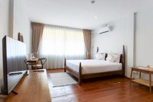 a bedroom with a bed and a television in it at Samer Boutique Stay in Bangkok