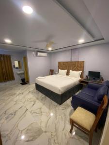 a bedroom with a bed and a couch and a table at Hotel HiCity Comfort Near DLF Cyber City & AIG Hospital in Hyderabad