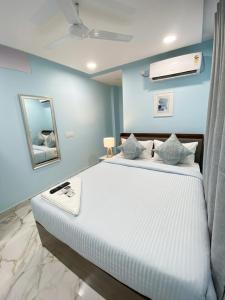 a bedroom with a large white bed with blue walls at Hotel HiCity Comfort Near DLF Cyber City & AIG Hospital in Hyderabad +18 photos