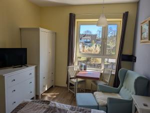 a bedroom with a table and chairs and a window at Armarova Ihre Ferienpension in Cuxhaven