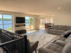 a living room with a couch and a television at View Spa and St-Lawrence River - The DG Chalet in Sainte-Petronille