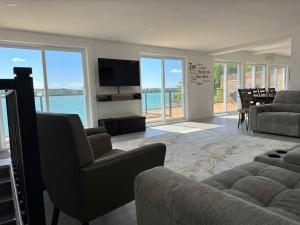 a living room with a couch and a television at View Spa and St-Lawrence River - The DG Chalet in Sainte-Petronille