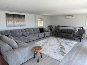 a living room with a large couch and a table at View Spa and St-Lawrence River - The DG Chalet in Sainte-Petronille