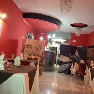 um restaurante com mesas e cadeiras e paredes vermelhas em Lorenzo B&B em Olevano sul Tusciano
