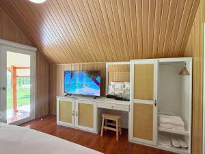 a bedroom with a bed and a tv on a desk at Ther lay beach resort in Sikao
