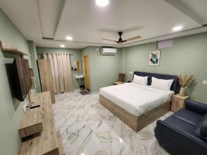 a bedroom with a bed and a tv and a couch at Hotel HiCity Comfort Near DLF Cyber City & AIG Hospital in Hyderabad