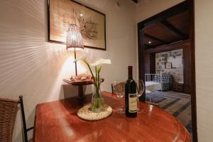 a table with a bottle of wine and a lamp at Apartment Stern in Perast