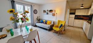 a kitchen and living room with a table and chairs at Fleur De Cerisier Vendée in Challans