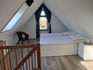 ein Schlafzimmer mit einem Bett und eine Treppe mit einem Fenster in der Unterkunft Beekenhof in Bommelsen
