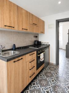 a kitchen with wooden cabinets and a sink at Iris -Paola Modern Townhouse in Paola