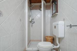 a white bathroom with a toilet and a shower at Casa Gianpiero San Teodoro in San Teodoro +13 photos