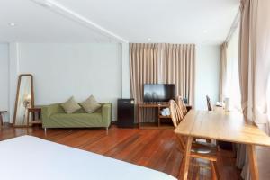 a living room with a green couch and a television at Samer Boutique Stay in Bangkok +19 photos