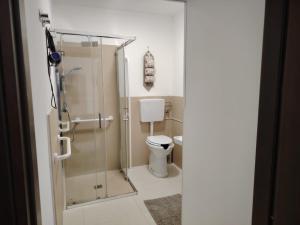 a bathroom with a toilet and a glass shower at Tulla's in Giardini Naxos +30 photos