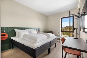 a bedroom with a large bed and a large window at Comfort Hotel Grenlandsporten in Langangen +24 photos