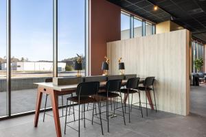 a table and chairs in a room with windows at Comfort Hotel Grenlandsporten in Langangen