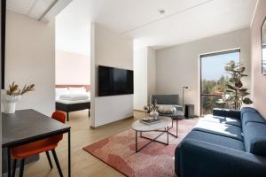 a living room with a blue couch and a table at Comfort Hotel Grenlandsporten in Langangen