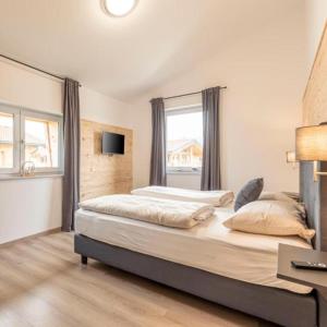 a bedroom with a large bed and a window at Luxalps- BergZeit- Inzell- Sommerpool- Sauna- Wandern- Chiemgau Card in Inzell