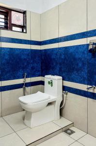 a bathroom with a toilet with blue and white stripes at CloudNine Stay in Sultan Bathery