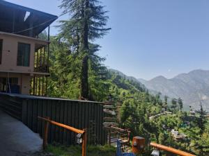 a house on the side of a hill with trees at Bhindeshi Tara Stays Jibhi Mihar in Jibhi