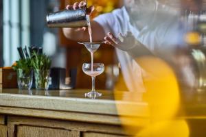 a person pouring a drink into a glass at The Old Bridge in Huntingdon