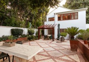 a patio with a table and a house at Waterkloof Apartments in Pretoria