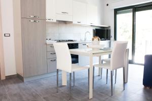 a kitchen with a white table and white chairs at Casa Corvaja in Taormina