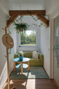 a living room with a green couch and a table at House of Flow in Pritzwalk
