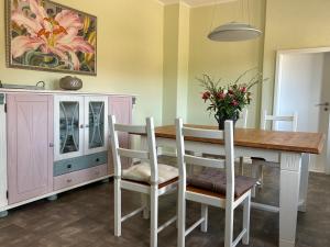a dining room with a table and chairs and a cabinet at Landidyll in Uelzen