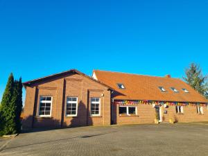 a brick building with a string of flags on it at House of Flow in Pritzwalk +9 photos