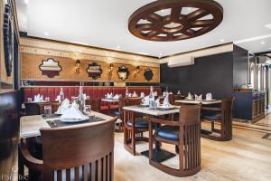 a restaurant with wooden tables and chairs and a ceiling at Paradise Hotels in Pahalgām