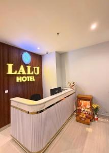 a lobby with a reception desk and a hotel sign at LALU Hotel in Phú Quốc