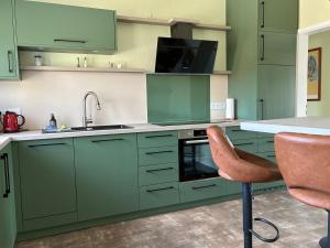 a kitchen with green cabinets and a sink and a chair at Landidyll in Uelzen +30 photos