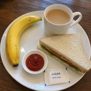 a plate with a banana and a sandwich and a cup of coffee at Hotel The Galaxy in Dabok