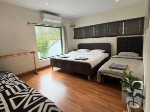a bedroom with two beds and a window at Cha-am Pool Villa in Ban Bo Prakhon