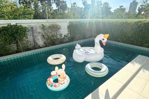 a swimming pool with inflatable toys in the water at Cha-am Pool Villa in Ban Bo Prakhon