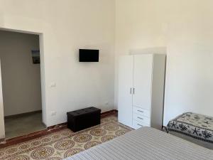 a bedroom with a bed and a dresser with a television at Residence Lion in San Vito lo Capo